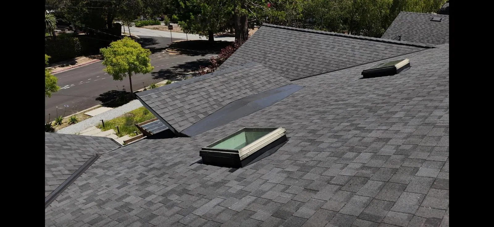Completed residential shingle roof with skylights
